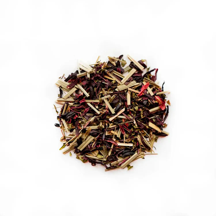 Heap of mixed dried tea leaves: hibiscus, lemongrass, and mint.